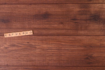 Frases de motivación con letras sobre baldosas de madera individuales con un fondo de madera rústica y roble claro.