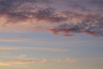    Beautiful evening blue sky at sunset with flaming bright light clouds. A warm summer evening at sunset. Bright sunset.         
