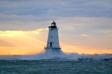 Waves breaking against the Ludington lighthouse at sunset 
