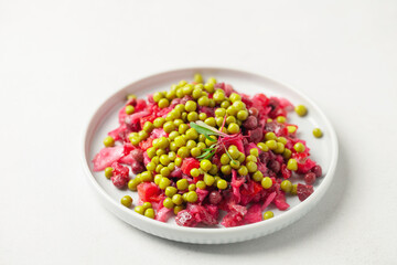 Salad vinaigrette with beets and vegetables on a plate on the table. Healthy diet