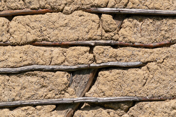 Fototapeta premium Wall made of mixture dirt, mud and wheat chaff supported with wooden sticks