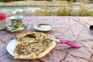 Homemade food at a roadside cafe on the way to Arkhyz. Hychiny with meat and onion with sour cream...