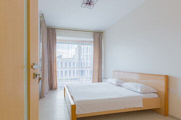 interior of a bedroom with a large bed in light colors