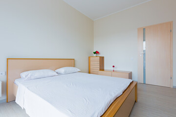 interior of a bedroom with a large bed in light colors