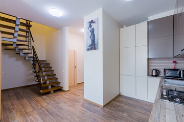 kitchen interior in gray studio with corridor and stairs