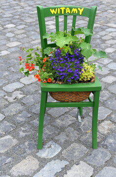 Stuhl mit Blumen und der Aufschrift: "Witamy"