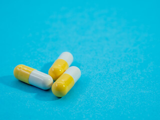 Multicolored medical capsules on a blue background.