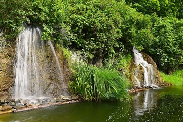 Fototapeta na wymiar Beautiful small waterfall with a rock in nature. Brno castle Spilberk.