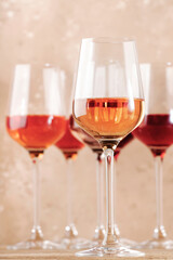 Rose wine glasses on the beige table. Rosado, rosato or blush wine tasting concept, negative space