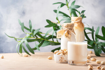 Obraz na płótnie Canvas Cashew milk in bottles. Non dairy alternative vegan drink. Negative space
