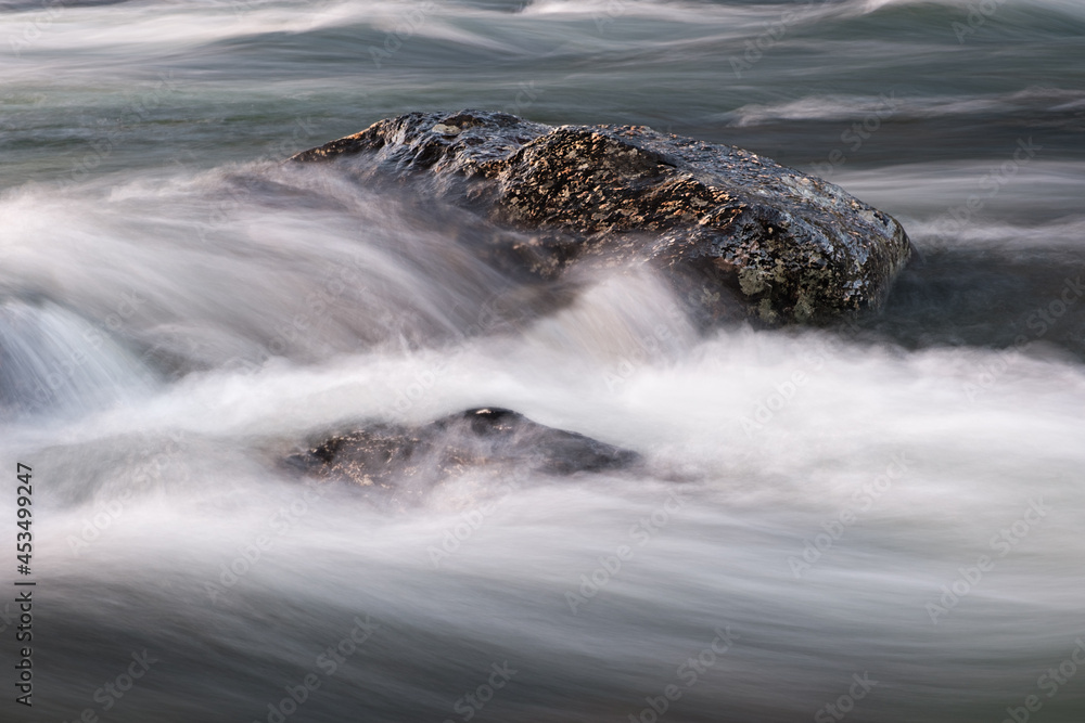 Poster abstract background from long exposure of water stream in a mountain river close-up