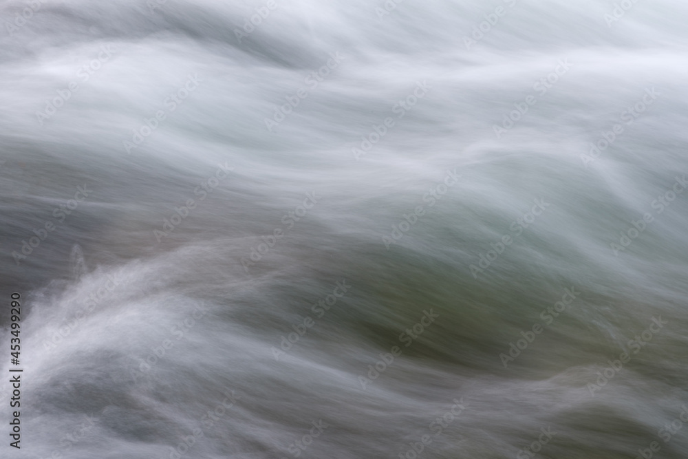 Poster abstract background from long exposure of water stream in a mountain river close-up