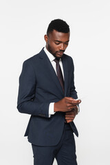bearded african american businessman in suit messaging on smartphone isolated on grey