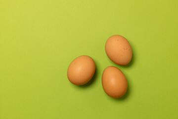 Organic brown chicken eggs on a green background. Minimal creative art