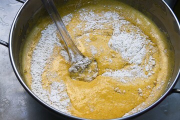 A bowl in which the ingredients are being mixed to make a carrot cake