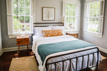 A guest bedroom with a queen sized bed and nightstand at a short term rental small cottage style house
