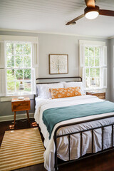 A guest bedroom with a queen sized bed and nightstand at a short term rental small cottage style house