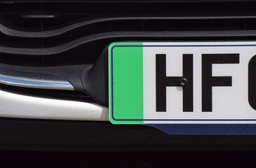 A close up of the green strip on a British car number plate that demonstrates the vehicle is an...