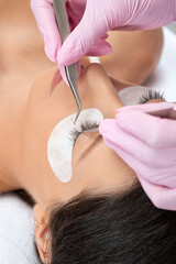 Beautiful Woman with long eyelashes in a beauty salon. Eyelash extension procedure. Lashes close up