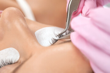 Beautiful Woman with long eyelashes in a beauty salon. Eyelash extension procedure. Lashes close up