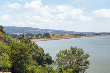 Beautiful sunny day  with clouds over Danube river with forest along riverside in Serbia. Danube riverbed.