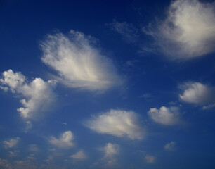 Scattered white clouds at dawn with intense blue sky in the background