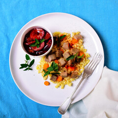 Salad in a large white plate and homemade bun. Blue background