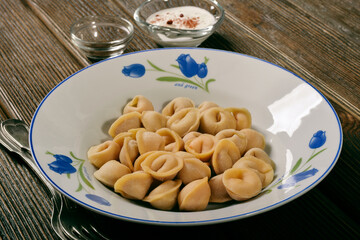 Raw dumplings in a soup plate. Handmade