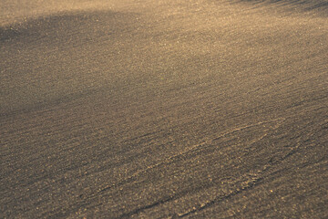 Holidays by the sea, sand on the beach and gentle waves. the setting sun is reflected in the golden sand of the beach