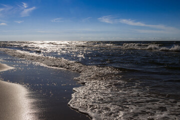 Vacation by the sea, ocean, beach, waves and beautiful sky. Strong wind and white clouds over the sea somewhere in Poland