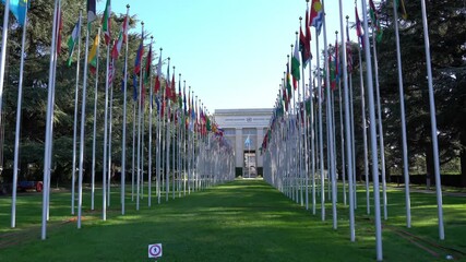 Country flags blowing in the wind at United Nations Palace at City of Geneva on a sunny summer morning. Movie shot August 28th, 2021, Geneva, Switzerland.