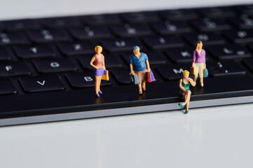Obraz premium miniature people with shopping bags on a black computer keyboard as symbolism for online shopping
