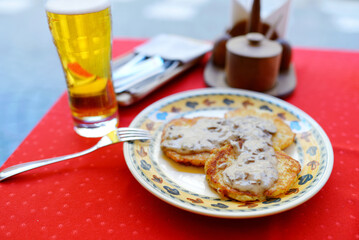 Traditional Lithuanian potato pancakes called bulviniai blynai, served with deliciuos mushroom sauce.