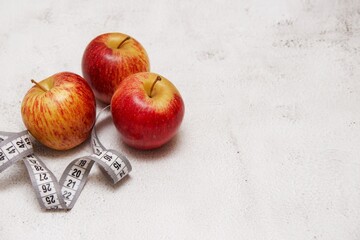 apples and a centimeter tape on a light background.  diet and healthy eating