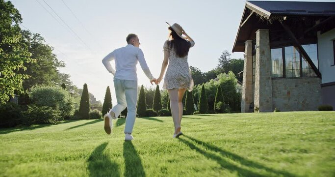 Couple running in grassy yard together