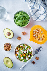 Roasted pumpkin avocado arugula goat cheese salad in a plate