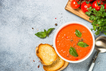 Tomato soup with basil. Summer cold vegan dish. Top view at white background.