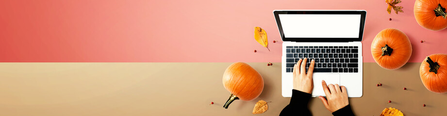 Fototapeta na wymiar Autumn pumpkins with person using a laptop computer