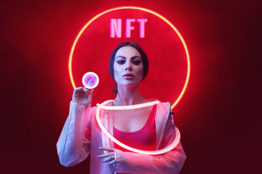 Beautiful woman in futuristic costume on dark background. Augmented reality, future technology, AI concept. Holographic interface to display data. Red neon light. - Powered by Adobe
