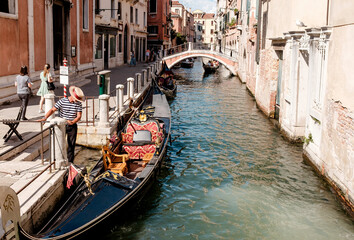 Gondolier at his boat in a canal in Venice/Italy