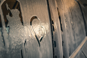 Drawn heart on blurred car glass. Close-up.