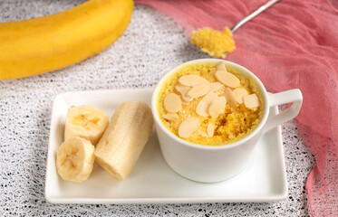 banana muffin in a mug on a plate. Fresh bananas next to homemade muffins. homemade magician cake is cooked in the microwave. Banana dessert, baked goods. High quality photo