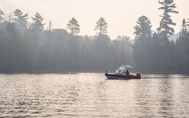 People are fishing and boating at Crane Lake, Voyageurs National Park, in smoke from wildfire 