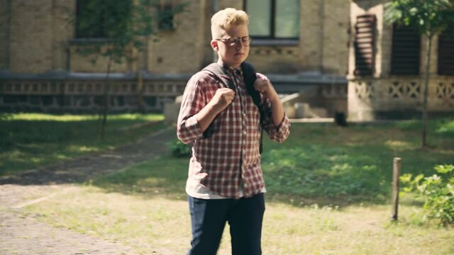 School children sitting on bench, laughing at insecure classmate, bullying