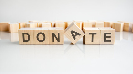 Donate text on a wooden blocks, gray background