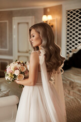 Stylish model girl in a vintage wedding dress posing with the bridal bouquet. Young woman wearing a luxurious wedding dress with a stylish bouquet of flowers in her hands