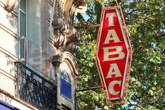Vieille enseigne vintage "Tabac" rouge, en fran&ccedil;ais, accroch&eacute;e &agrave; la fa&ccedil;ade d'un buraliste &agrave; Paris &ndash; ao&ucirc;t 2021 (France)
