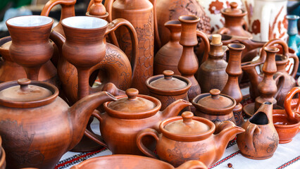 Fototapeta na wymiar Ukrainian pottery. Pottery museum in Ukrainian village Oposhnya, center of Ukrainian pottery production. Different pottery products: bowls, pitchers, plates in museum.