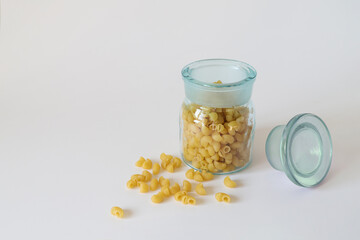 pasta in a glass jar is on a white surface