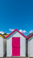 Fototapeta na wymiar Colourful beach houses. Row of multicolored beach huts against blue sky.
